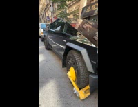 Black tesla cybertruck with tire clamp street