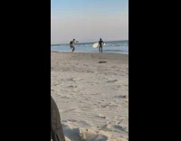 Guy hold surfboard tell photographer change location