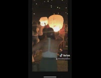 Girls light lantern and flies onto person
