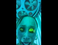 Woman slightly panicking inside vertical tanning bed 