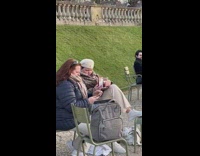Woman beside the statue takes picture of her drink