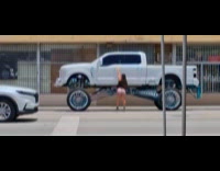 Woman rides at lifted pickup on street