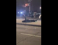 Guy lays on street divider and points