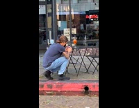 Blue shirt guy squats cocktail drink table 
