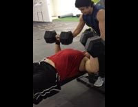 Guy bench press dumbells hits leg
