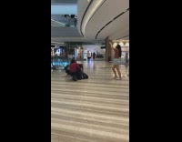 Lady squats next to suitcase red shirt