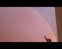 Person film huge rainbow arc during sunset