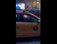 Two men ride tall bicycle at street
