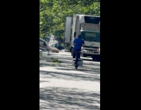 Man transporting air condition unit using electric scooter 