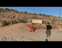 Man orange astronaut costume walk beach sand