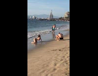 Collab IITW - Woman in bikini seductive poses at the beach shore - man in black shorts takes pictures