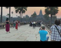 Girl jumps for picture in front of temple at sunrise