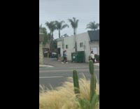 Two girls use green trash bin tripod