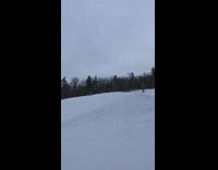 Snowboarder blue board frontflips over hump and falls in snow