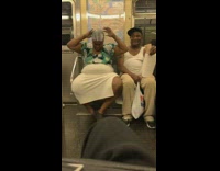 Pt. 2 Woman in blue green floral shirt applies hair relaxer on subway train