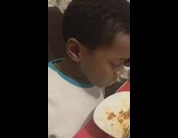 Kid eats food looks annoyed unamused 