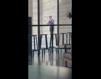 Man in dark blue top naughty poses in front of the wall