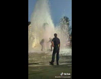 Two guys trying to turn off broken fire hydrant 
