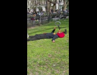 Man Lays on Ground with Hot Dogs in Mouth for Video 