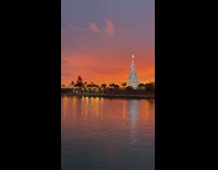 Guy standing by river watches sunset 