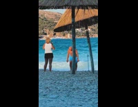 Shirtless bald guy blue shorts beach hut