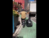 Man riding bike with dog on sidecar