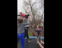 Boy in red shirt almost falls off trampoline 