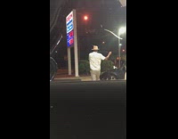 Guy brown straw hat dances gas station 