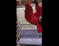 Woman in red hangs from train bars 