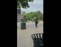 Man in a rat costume on top of a barrier