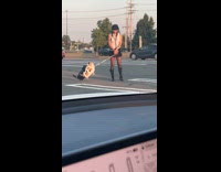 Collab IITW - Woman poses with two leashed inflatable dogs
