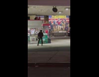 Guy rollerblading around at an empty gas station 
