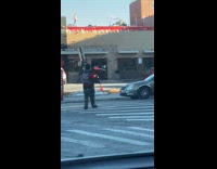 Guy wearing clown make up juggling on the street at the crosswalk 
