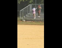 Two women dress metal benches baseball field