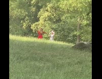 Red dress girl dances grass field nature