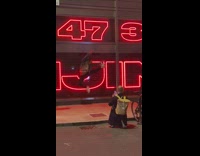 Man jump kick street red glow letters