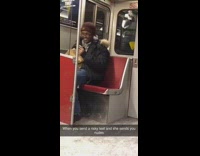 Guy wearing earphones headbangs to music on subway train