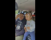 Little girl slaps guy in car say cheese