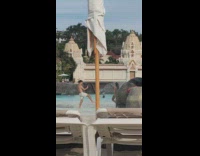 Woman in blue bikini splashed by shirtless man