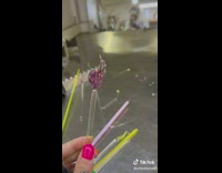 Woman glassblower makes purple glass hand