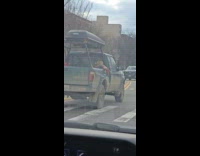 Green pickup truck with scarecrow on trunk