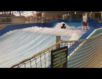 Woman falls off surfboard surf machine