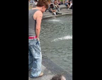 Man urinates on fountain with people around