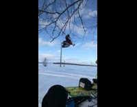 Red snowmobile jump fresh snow license plate