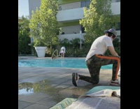 Blue bikini girl sits ground community pool 