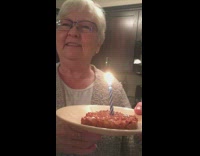 Grandma holds cat food cake with candle happy birthday 
