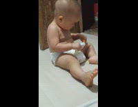 Baby on floor try to brush teeth
