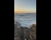 Ocean waves crash on rocky shore sunset