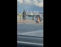 Man walks on boardwalk pier and takes video