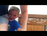 Mom removing splinter from sons foot